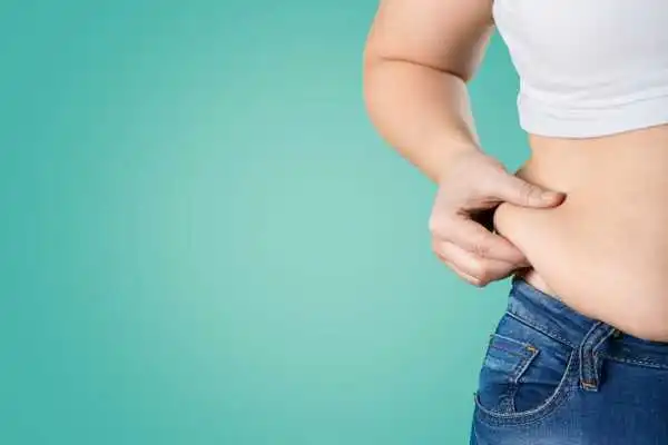 Image of woman pinching her love handles to show weight gain Uckfield